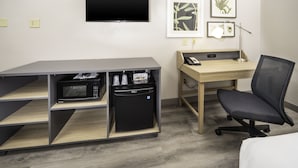 A hotel room with a flat-screen TV, a desk with a computer, a chair, a microwave, and a mini-fridge. - Country Inn & Suites by Radisson, Stone Mountain, GA (Stone Mountain)