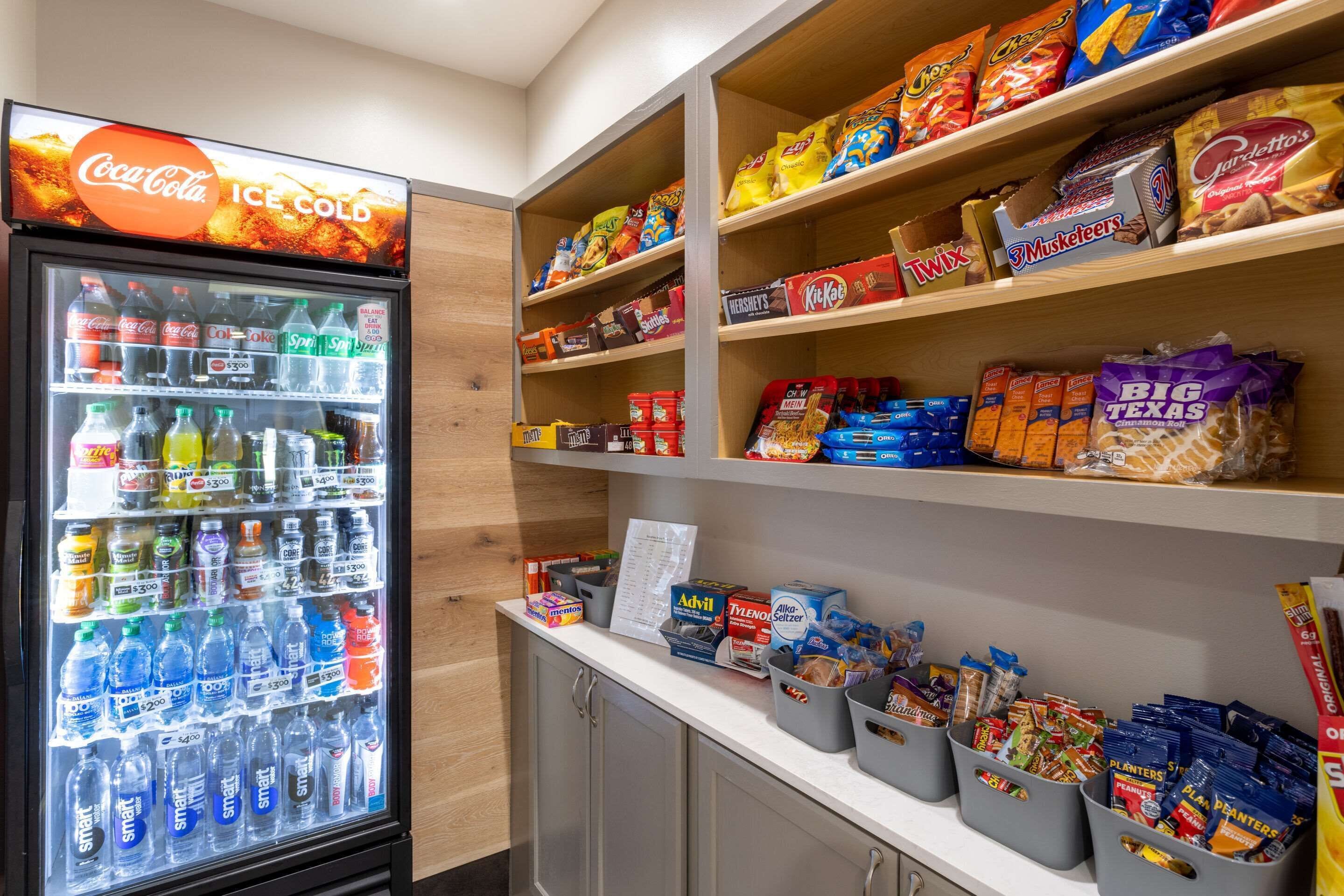 A vending machine stocked with various drinks and snacks, including Coca-Cola, Sprite, and Doritos.