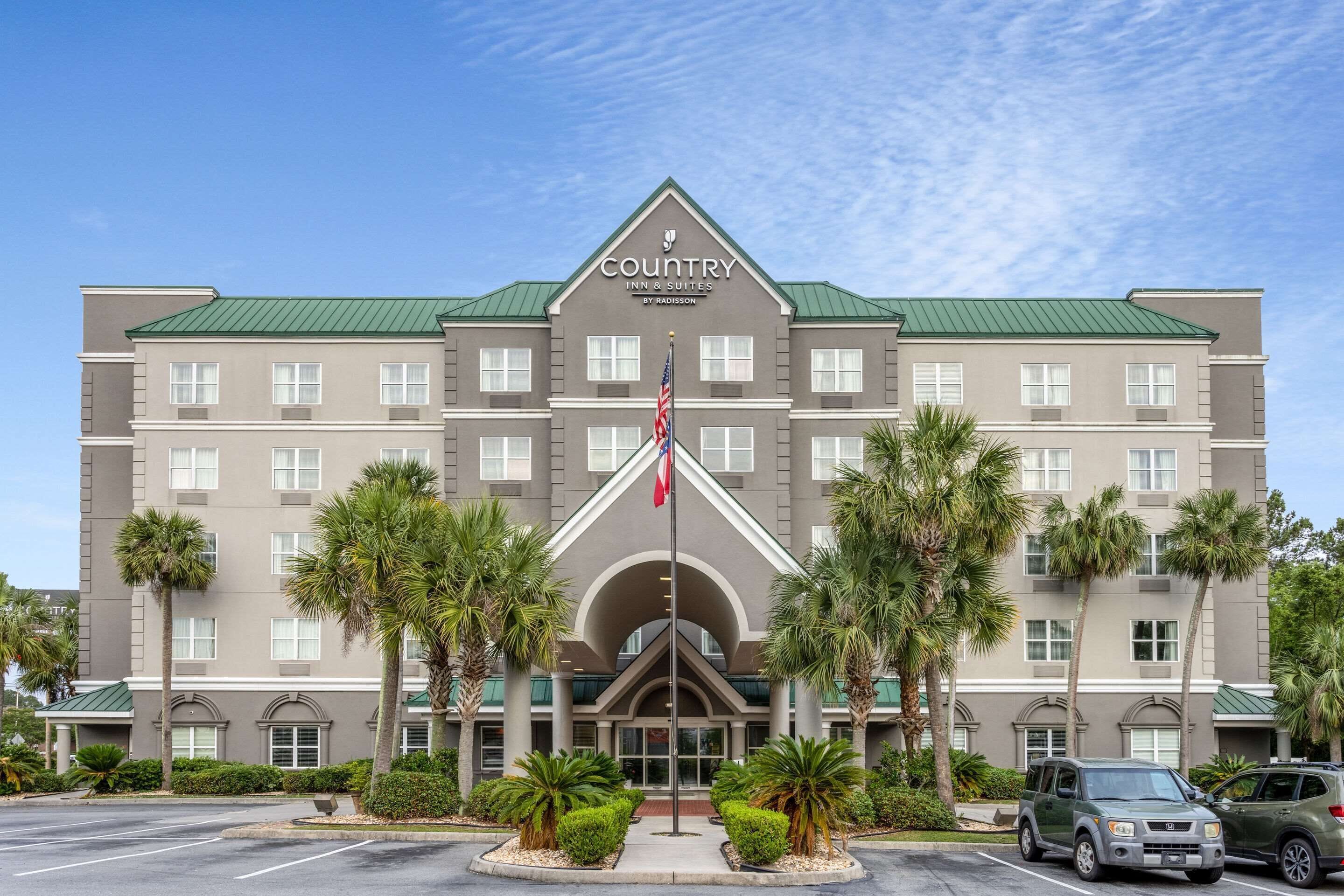 Un hôtel Country Inn & Suites dont la façade est symétrique, avec de nombreuses fenêtres et une entrée centrale.
