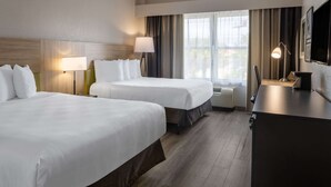 A hotel room with two beds, a desk, a lamp, and a large window with curtains. - Country Inn & Suites by Radisson, Valdosta, GA (Valdosta)