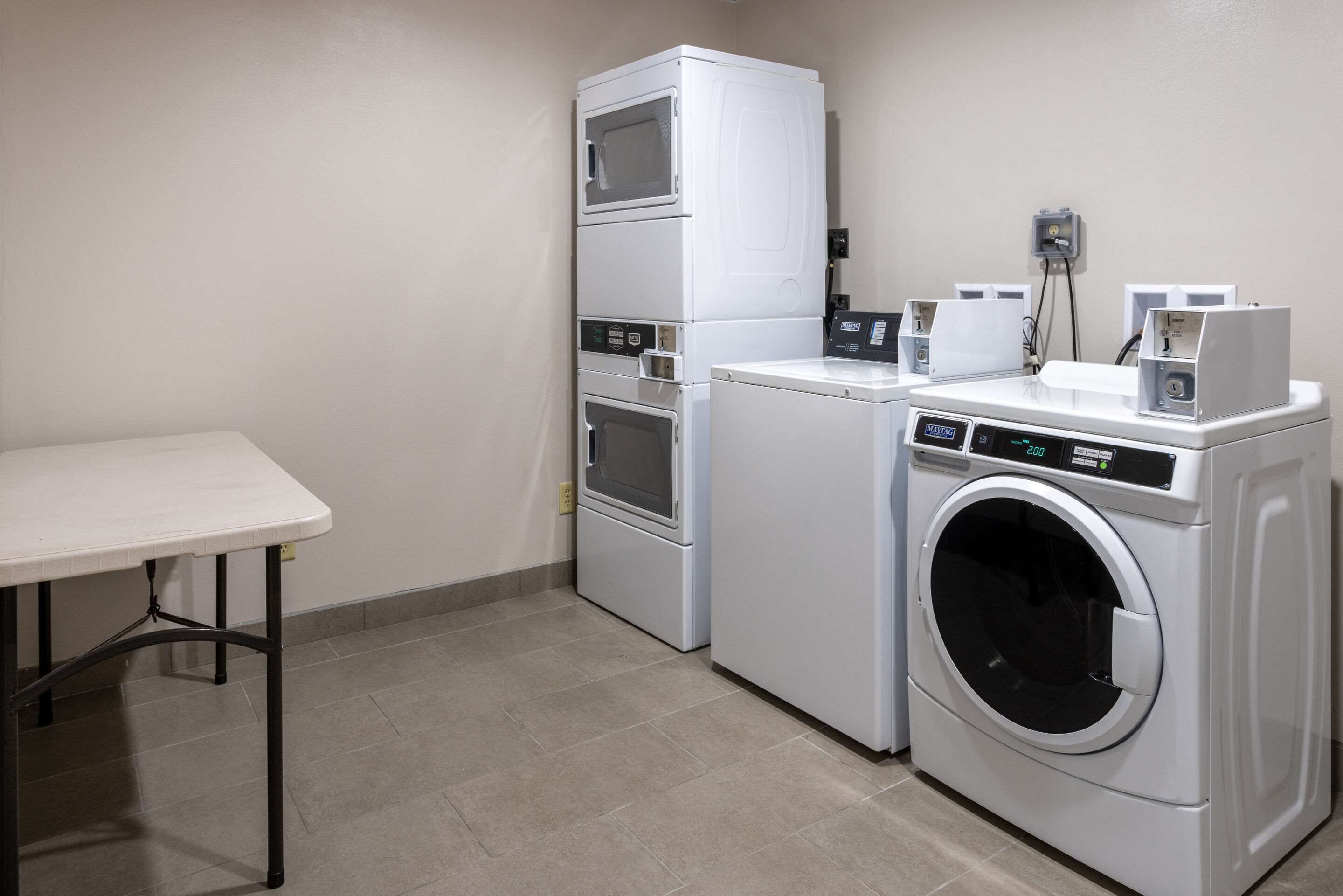 A laundry room with a washing machine, dryer, and stacked appliances.