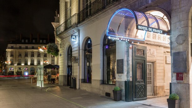 Fachada de hotel de estilo arquitectónico clásico, con ventanas en arco y una entrada destacada.