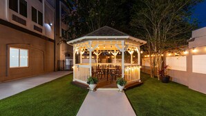 A gazebo with a dining area, surrounded by a well-maintained lawn and potted plants. - La Quinta Inn & Suites by Wyndham Brownsville North (Brownsville)