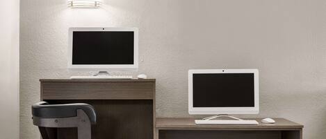 A workspace with two monitors, a keyboard, a mouse, and a chair.