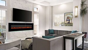 Una sala de estar moderna con chimenea, televisor de pantalla plana y una zona de estar acogedora.