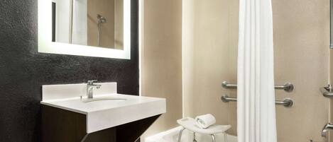 Une salle de bain moderne avec un lavabo blanc, une baignoire et une douche.