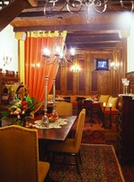 Comedor tradicional con una mesa de madera, sillas y una lámpara de araña.
