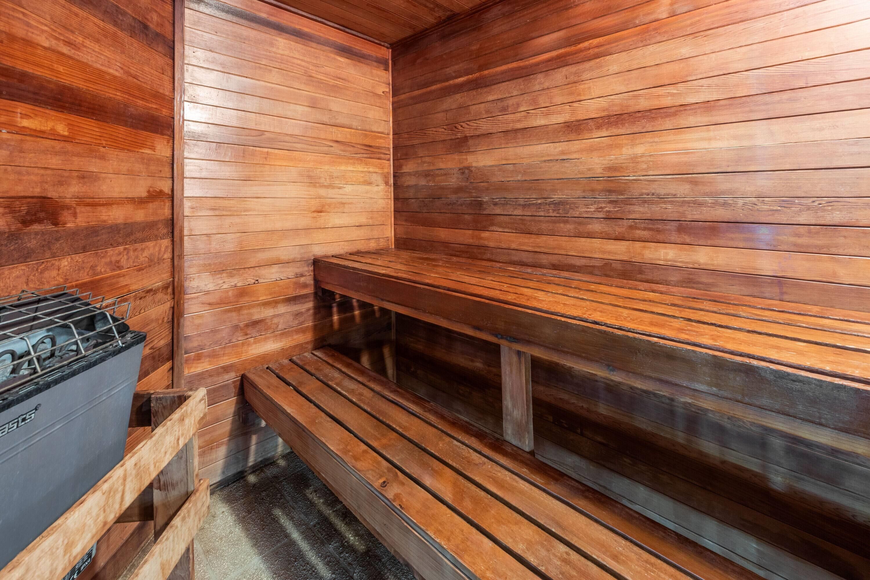 Una sauna con bancos de madera y un generador de vapor.