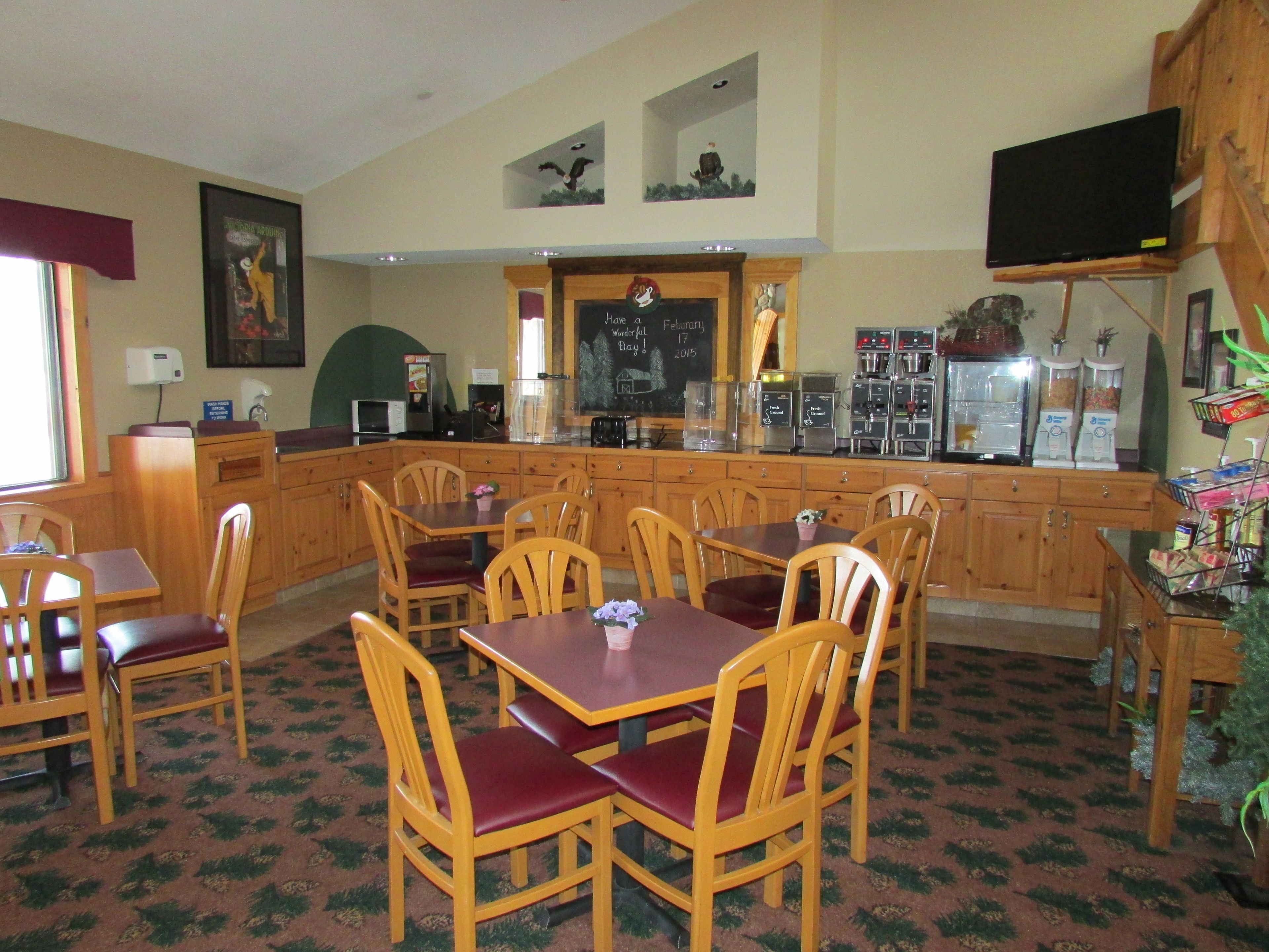 A cozy restaurant with wooden furniture, a bar area, and a chalkboard menu.