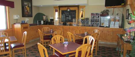 A cozy restaurant with wooden furniture, a bar area, and a chalkboard menu.