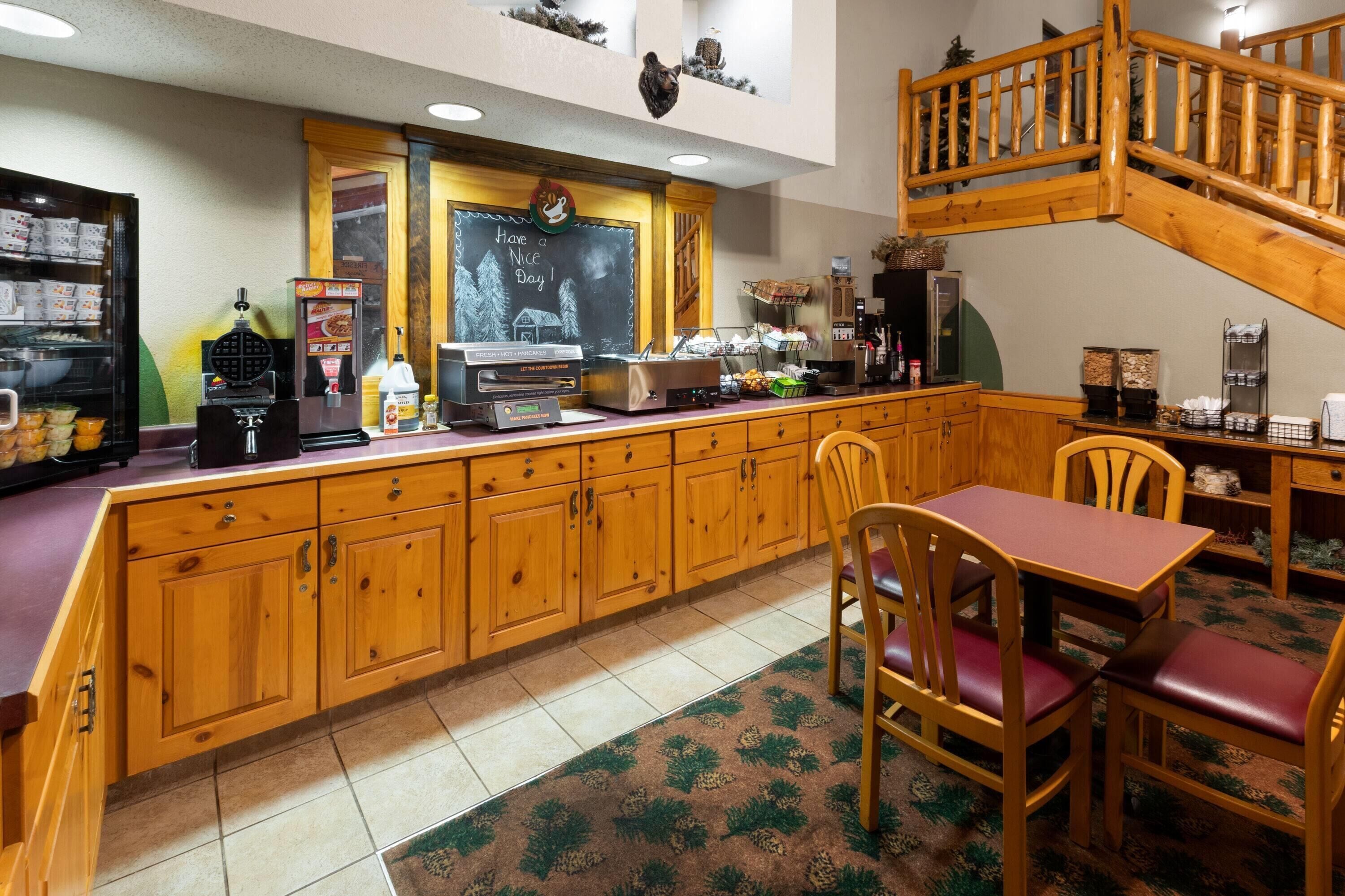 A cozy cafe with wooden furniture, a chalkboard menu, and a staircase.