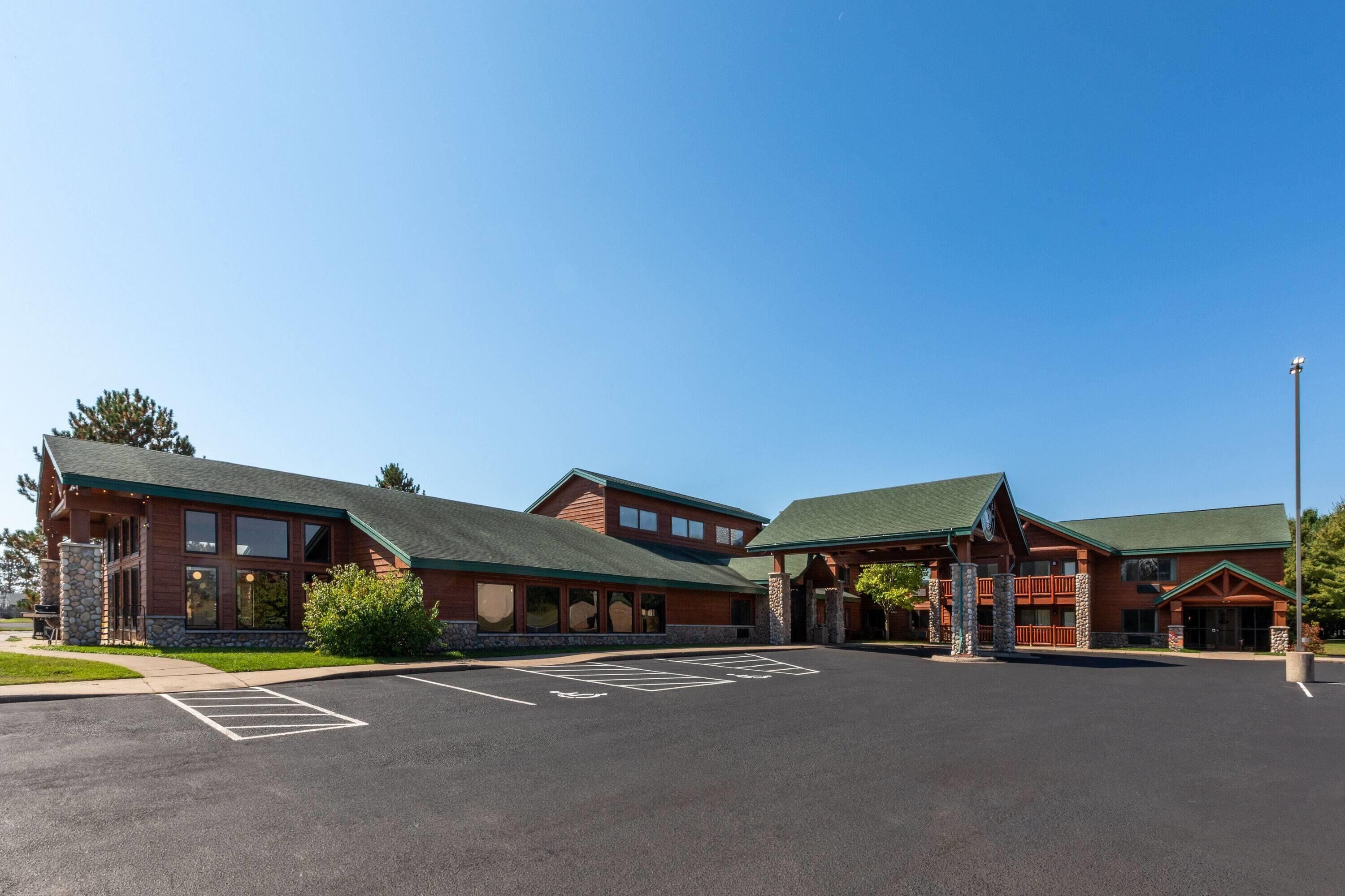 A lodge with a large parking lot and a building with a green roof and stone facade.