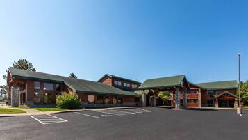 A lodge with a large parking lot and a building with a green roof and stone facade.