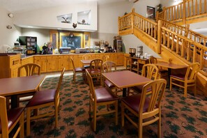 Un restaurant chaleureux, avec des meubles en bois, un menu écrit à la craie et un escalier.