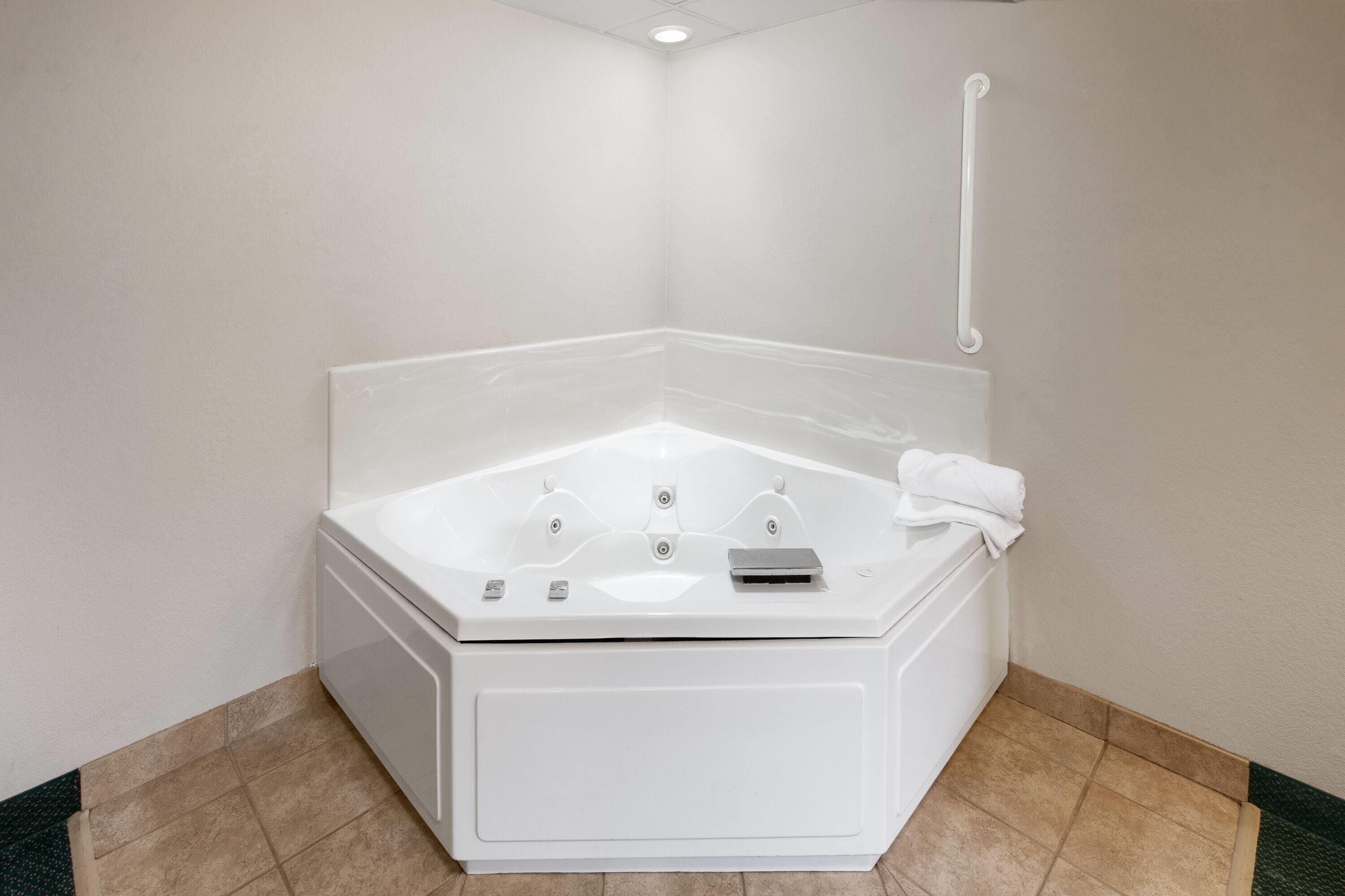 Une petite salle de bain avec une baignoire blanche, un porte-serviettes et un pommeau de douche.