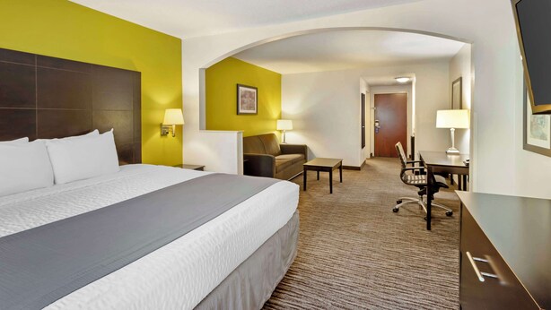 Ein Hotelzimmer mit einem großen Bett, einem Schreibtisch, einem Stuhl und einem Sofa.