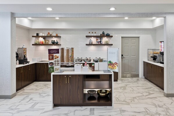 A modern kitchen with marble flooring, wooden cabinets, and a central island.
