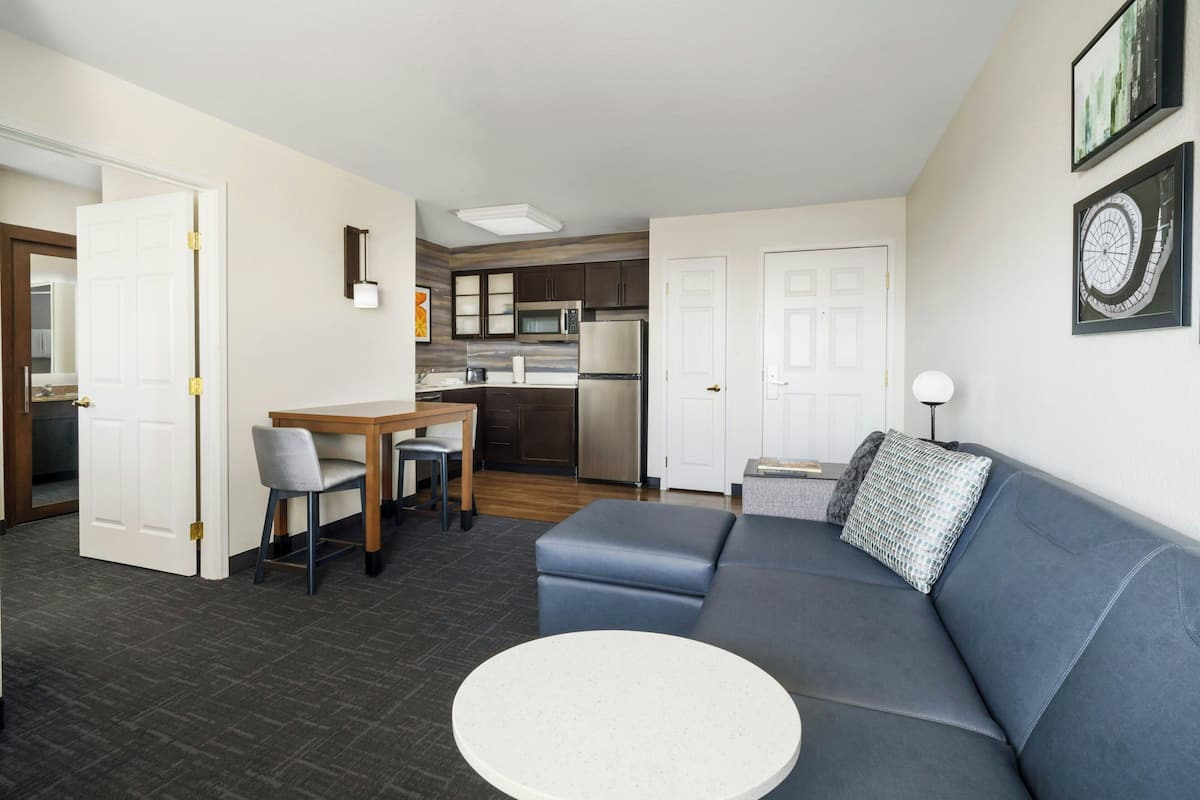 A modern apartment with a living room, dining area, and kitchen.