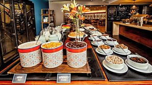 A buffet with various food items and a sign indicating 'Cereales'. - Time Suite - Comfort Apartments (Santiago)