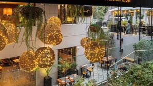 A restaurant named 'Rugendas' with outdoor seating and hanging decorative lights. - Time Suite - Comfort Apartments (Santiago)
