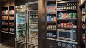 A self-service food station with refrigerated beverages, snacks, and a microwave. - Courtyard Fort Worth I-30 West Near Naval Air Station-JRB (Fort Worth)
