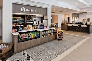 Tienda de hotel con bebidas frías, aperitivos y una zona de bar.