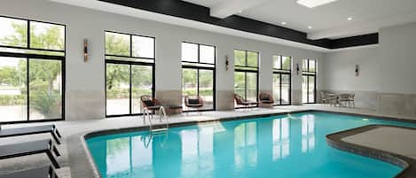 Una piscina techada, sillones reclinables de piscina