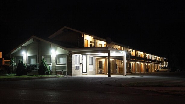 A two-story building with a covered entrance and a car parked in front. - Scottish Inns Albany (Albany)