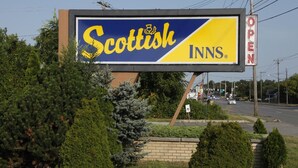 A billboard for Scottish Inns with a clear view of the road and surrounding greenery. - Scottish Inns Albany (Albany)