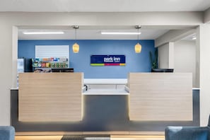 A reception area with a blue wall, a 'park inn' sign, and a snack bar with various packaged goods.