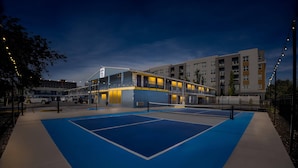 A multi-story building with a pool area, a parking lot, and a street with cars. - Park Inn by Radisson, Salt Lake City Downtown (Salt Lake City)