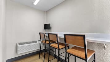 A room with a white wall, a white ceiling, a white radiator, and a white shelf.