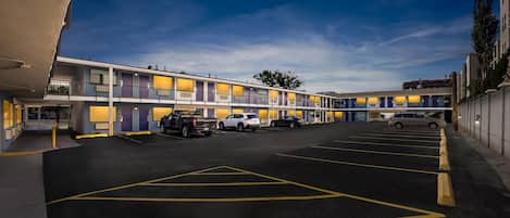 Un motel de varios pisos con estacionamiento.