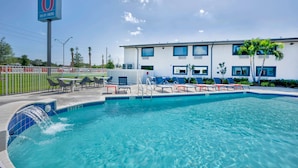 A swimming pool with a water feature, lounge chairs, and a sign indicating Wi-Fi availability. - Motel 6 Fort Lauderdale, FL (Fort Lauderdale)