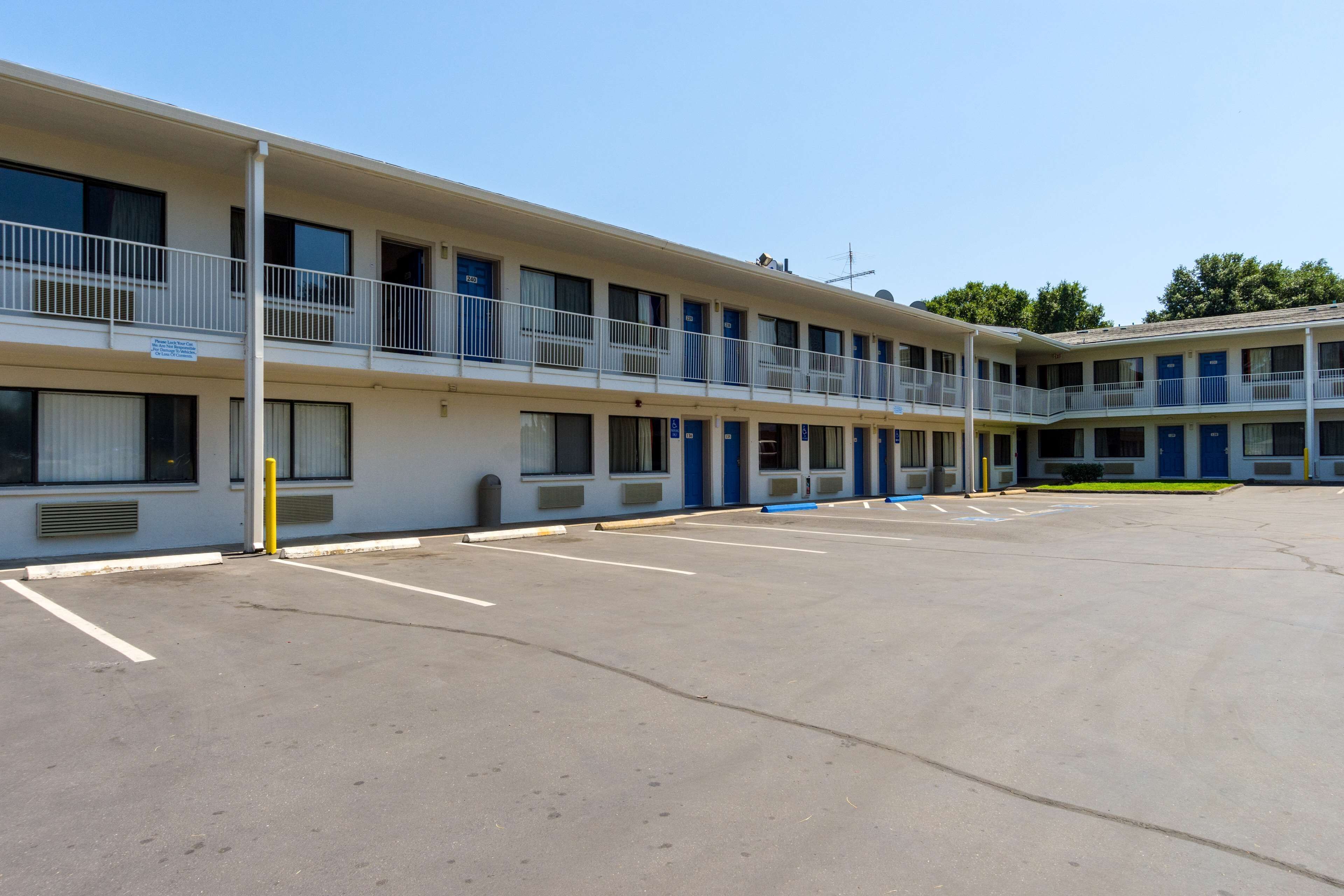 A multi-story motel with a parking lot.