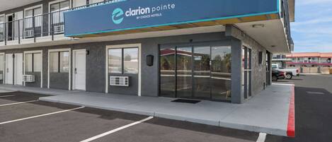 Un hotel con un toldo azul que muestra el nombre 'Clarion Pointe by Choice Hotels'.