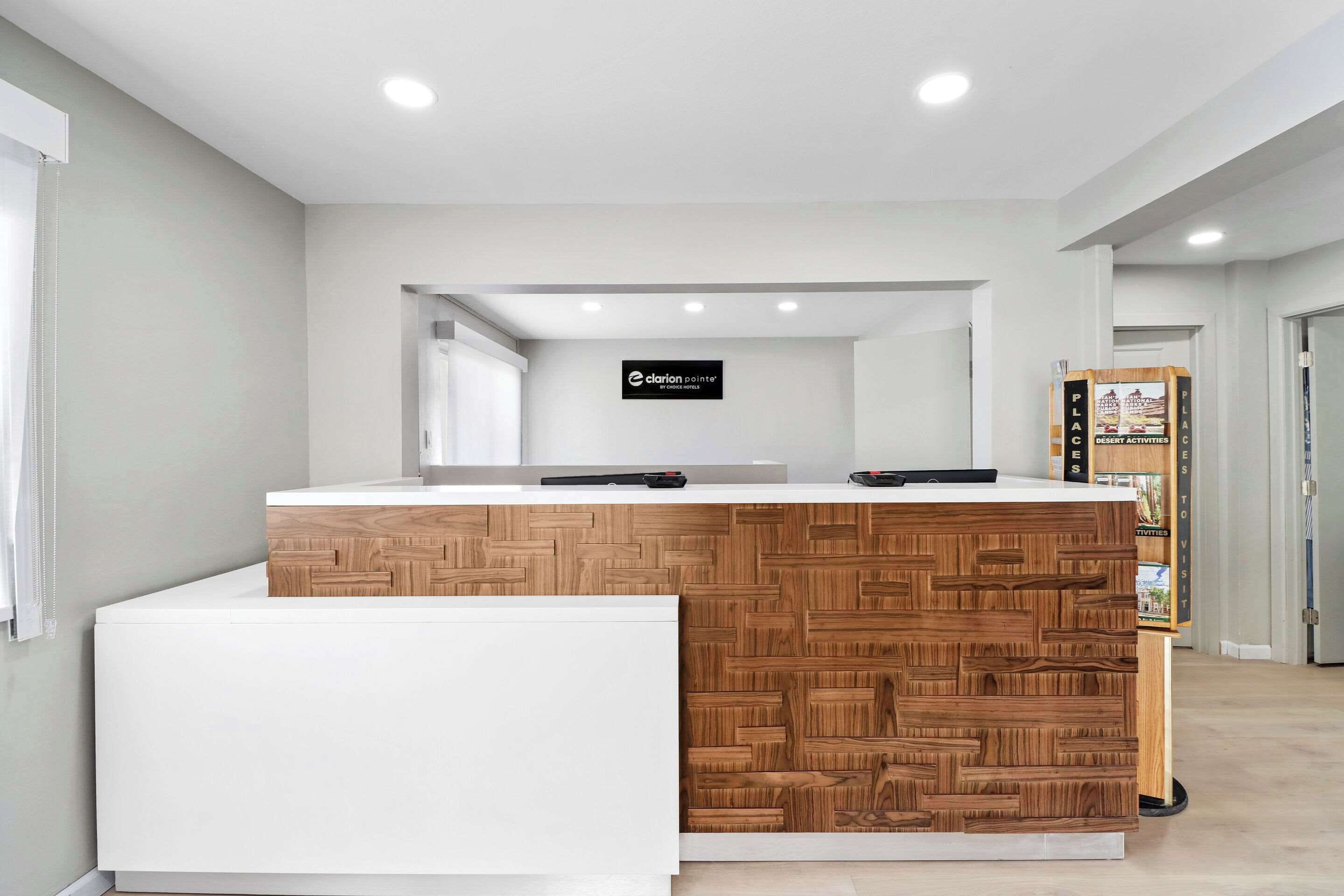 A reception desk with a wooden panel design, a sign for 'clarion painter', and a 'PLACES TO VISIT' board.