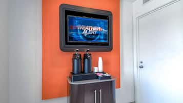 A weather alert display mounted on a wall, a coffee machine, and a cabinet with a door.