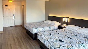 A hotel room with two beds, a nightstand, a phone, and a wall-mounted light fixture.