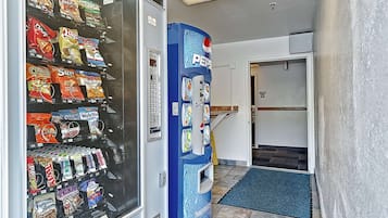 A vending machine with snacks and a Pepsi dispenser in a hallway.