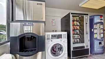 A laundromat with a Scotman refrigerator, a washing machine, and a Pepsi vending machine.