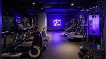 A gym with treadmills, elliptical machines, and free weights.