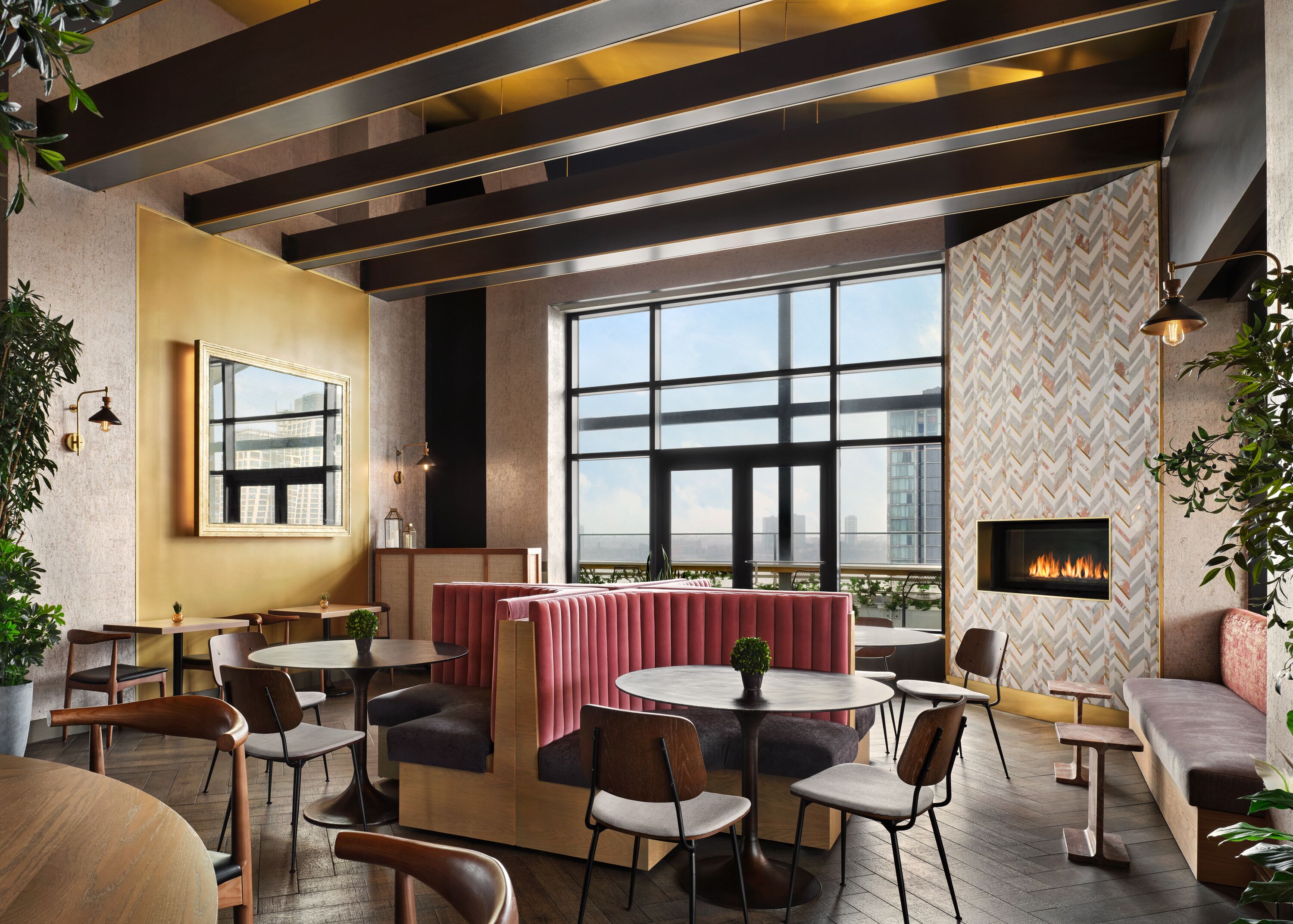 A modern lounge area with seating, a fireplace, and large windows offering a city view.