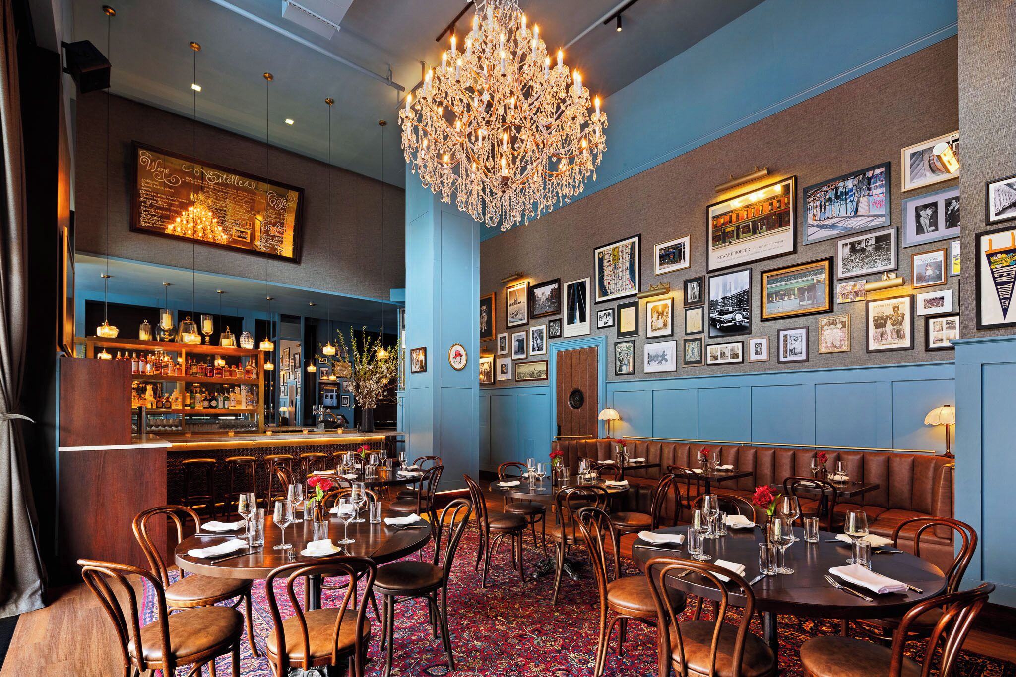 Un restaurant doté d’un bar, de plusieurs tables et d’un lustre.