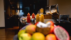 A breakfast buffet with various fruits and beverages. - Radisson Hotel Alphaville (Barueri)