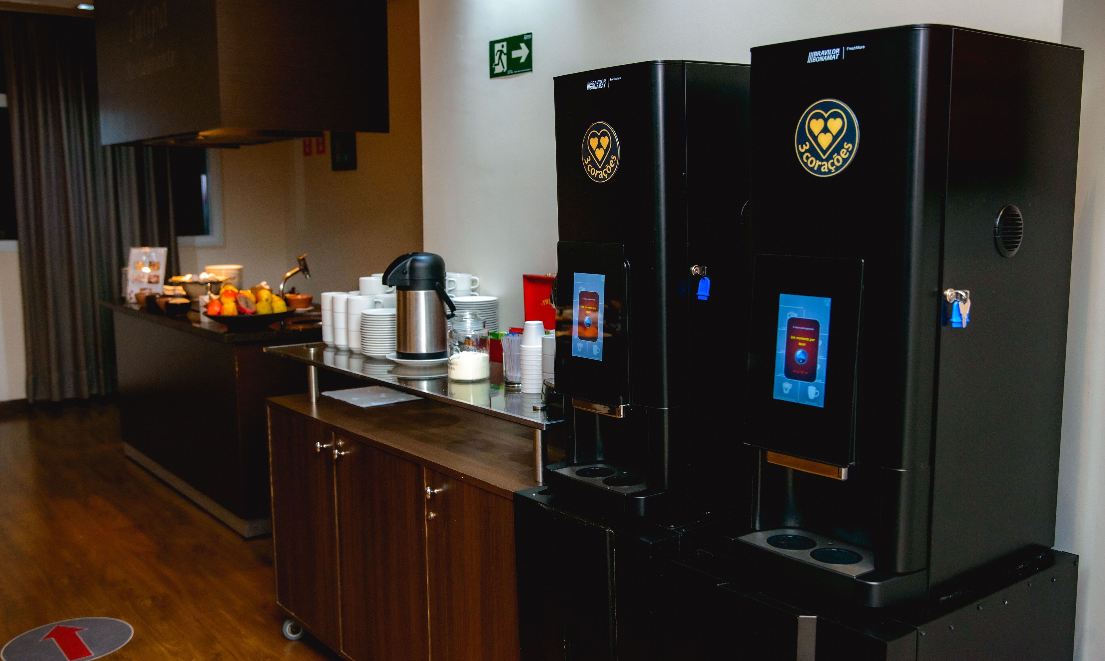 A kitchenette with two coffee machines, a sink, and a counter with various items.