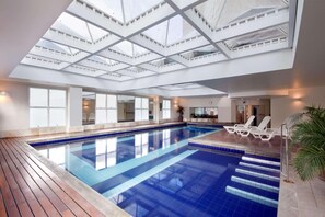 Una piscina cubierta, tumbonas