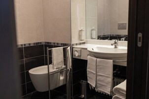 Un bagno moderno con toilette, bidet, lavabo e specchio.
