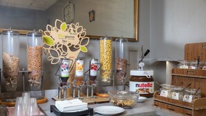 Una barra de desayuno con varios dispensadores de alimentos, incluyendo granola, yogur y Nutella.
