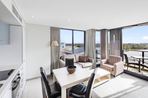 Una sala de estar moderna con comedor, ventanas amplias y vistas a la ciudad.